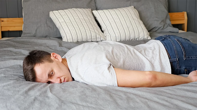 https://www.thesleepadvisors.co.uk/wp-content/uploads/2022/02/a-guy-trying-to-sleep-without-pillows.webp